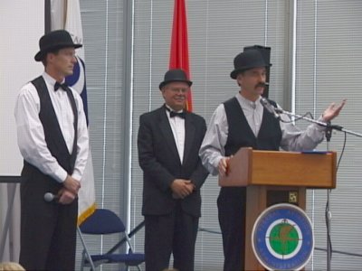 From left to right:  
             Wilbur Wright (Steve Woolridge of FAA), Charlie Taylor (Roland McKee of FAA),
             and Orville Wright (Charles Heckrotte of TRW)